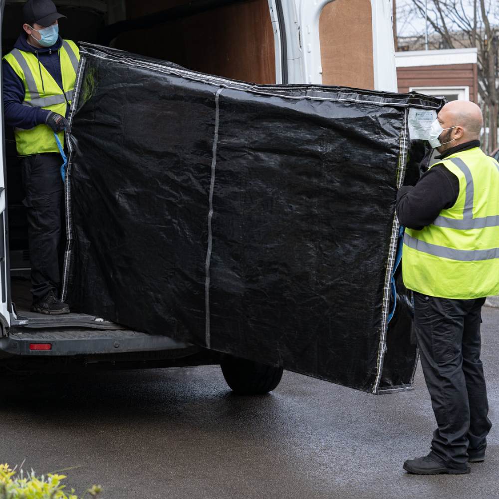 Removals men lifting a heavy mattress easily into removals van using a Britwrap black mattress bag